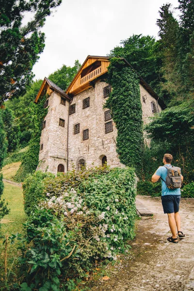 Man Backpack Looking Old Stone Building Covered Climbing Ivy Copy — Stock Photo, Image