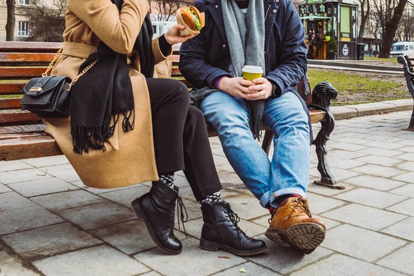 トリミング画像 ベンチに座ってファーストフードを飲んでお茶を飲むカップル 男性脚 — ストック写真