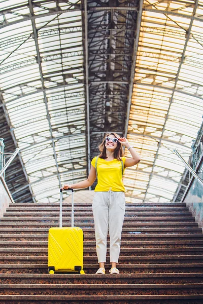 Улыбающаяся Счастливая Женщина Желтым Чемоданом Колёсах Лестнице Железнодорожного Вокзала — стоковое фото
