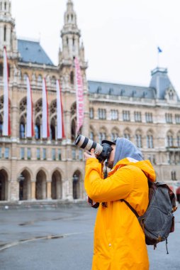 Profesyonel kameralı ve büyük mercekli bir adam şehrin mimarisinin fotokopi alanı turizmini çekiyor.