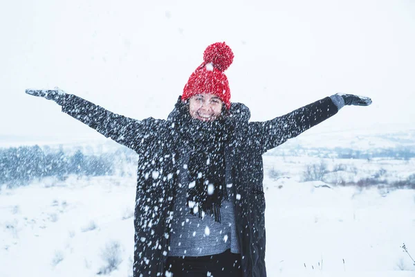 Gülümseyen Kırmızı Şapkalı Dışarıda Karla Oynayan Yetişkin Bir Kadın — Stok fotoğraf