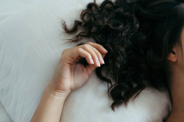 Kadın elini uzatır yatağa kıvırcık saçlarıyla