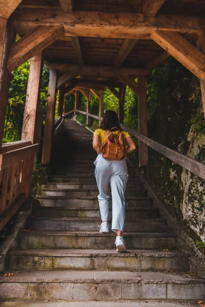 woman with brown leather walking up by stairs copy space