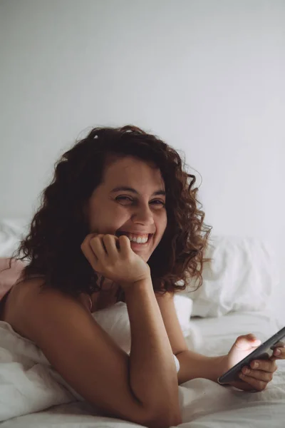 Joven Bonita Mujer Con Pelo Rizado Cama Con Teléfono Estilo —  Fotos de Stock