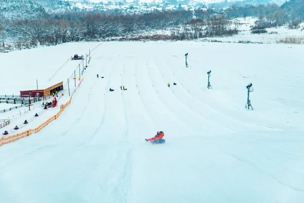 Menschen Die Spaß Haben Snow Tubing Durch Winter Hügel Hinunter — Stockfoto