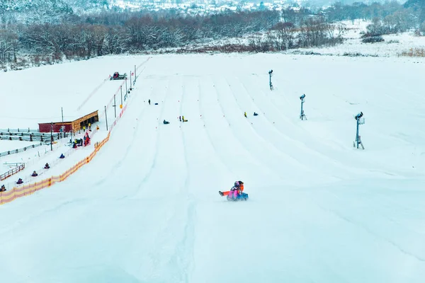 Menschen Die Spaß Haben Snow Tubing Durch Winter Hügel Hinunter — Stockfoto