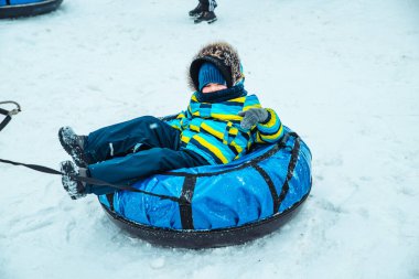 Kar tüpündeki küçük çocuk. kış zamanı aktiviteleri