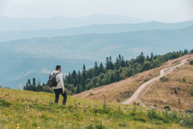 Sırt çantalı bir adam sonbahar mevsiminde dağlarda yürüyüş yapıyor.