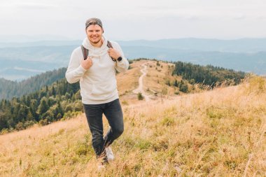 Sırt çantalı adam sonbahar dağlarında yürüyüş yapıyor. Kopya alanı.