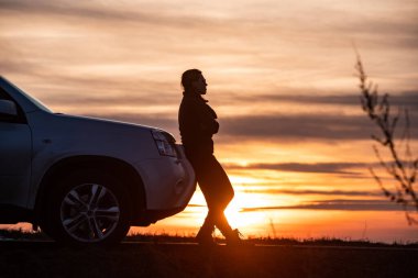 Kadın arka planda gün batımına yakın duruyor. Yolculuk. Boşluğu kopyala