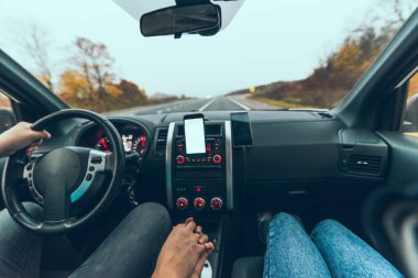 car travel concept autumn highway phone with white screen on dashboard copy space