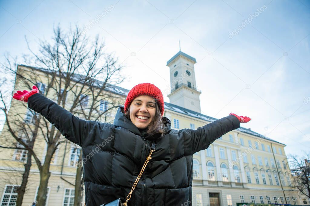 young adult woman traveler in front of lviv city hall winter urban tourism