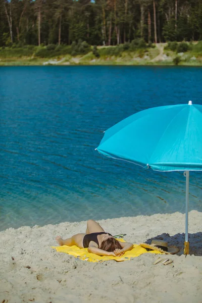 Frau Legt Sich Mit Blauem Sonnenschirm Auf Gelbe Decke Sandstrand — Stockfoto