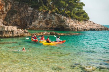 Pula, Hırvatistan - 5 Haziran 2019: deniz fotokopi alanının mavi körfezi yakınlarında kayak yapan insanlar