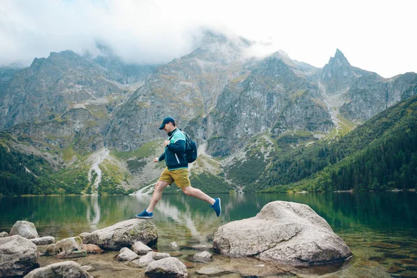 Silný Muž Skok Skály Pláži Jezera Horách Turistický Koncept — Stock fotografie