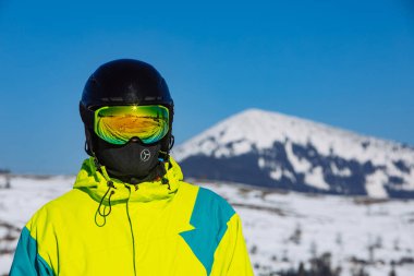 Miğferli ve kar maskeli adam. Yansıma. Kış aktivitesi. güneşli bir gün