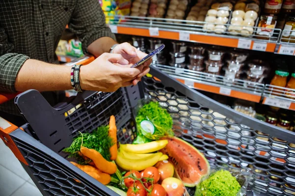Mann Mit Smartphone Geht Supermarkt Einkaufen — Stockfoto