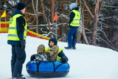 LVIV, UKRAINE - 7 Ocak 2019: kış eğlencesi aktiviteleri. Tepeden aşağıya kar borusuyla git. itme