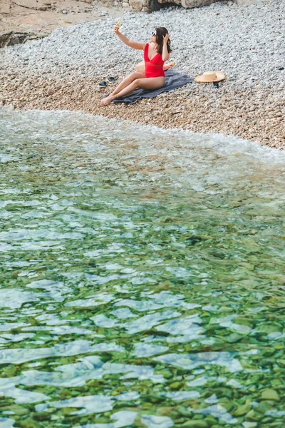 Joven Bonita Mujer Traje Baño Rojo Sentado Playa Rocosa Con — Foto de Stock