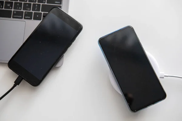 Два Телефони Один Підключається Дроту Інший Бездротовому Зарядному Пристрої Вид — стокове фото