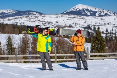 Arkasında snowboard dağları olan iki adam. kış sporu yaşam tarzı