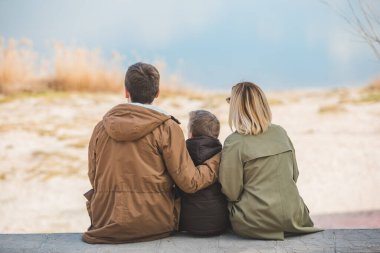 Sahilde gölü gören genç ve güzel bir aile. sonbahar sezonu