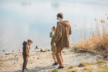 güneşli sonbahar gününde plajda yürüyen ağaç ailesi. boş zaman
