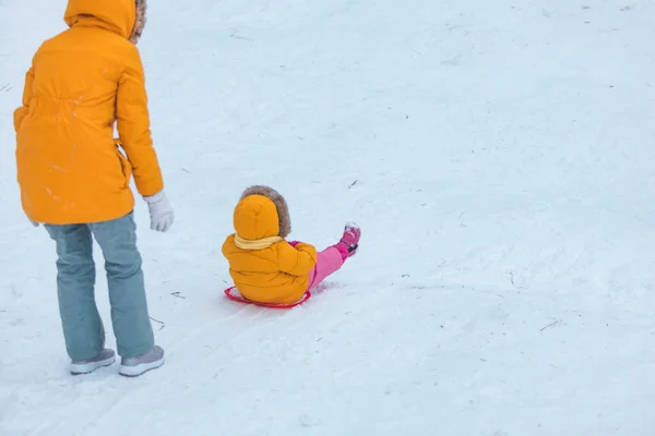 母亲带着女儿从雪山冬季滑落 — 图库照片