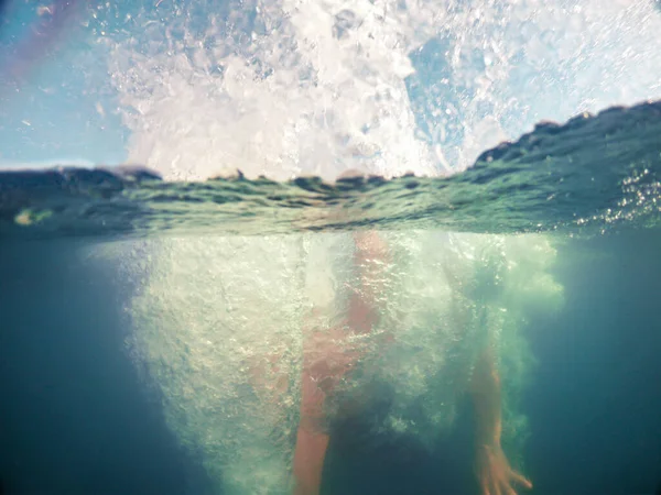 青い澄んだ水の夏の時間にジャンプする男 — ストック写真