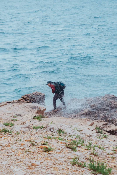 波が彼を覆うと男は濡れる 荒天だ 海岸線 — ストック写真