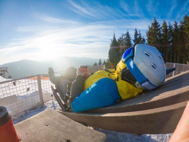 Kışın tepesinde gün batımında manzaralı sıcak çay içen bir kadın. kayak ve snowboard yaşam tarzı