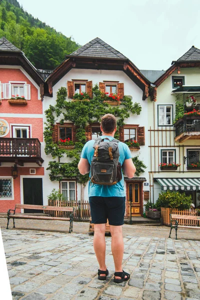 traveler with backpack at central city square in hallstatt summer time