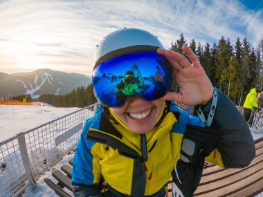 Arkadaşlar karlı tepenin üstünde fotoğraf çekerken eğleniyorlar. Gözlüklerdeki yansıma. Kayak ve snowboard. kış yaşam tarzı