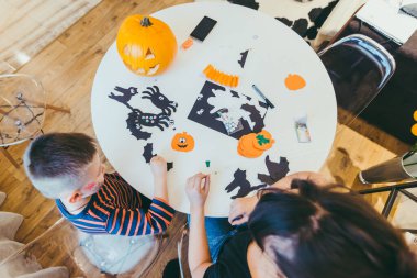 Küçük oğlu olan genç bir anne Cadılar Bayramı 'nda aile için örümcekler yapıyor.