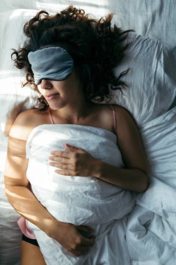 Sabah vakti maskeyle uyuyan bir kadın.