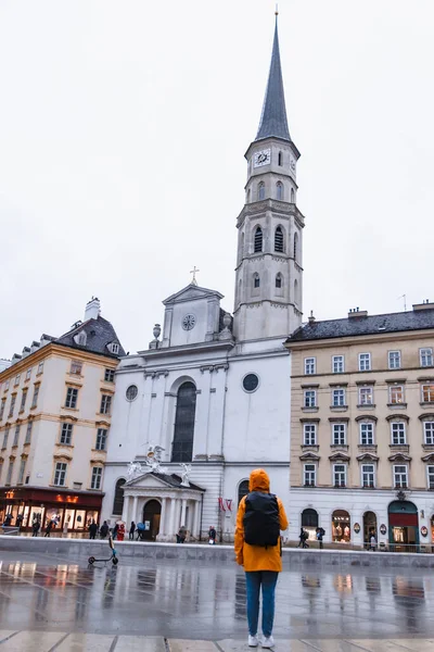 Γυναίκα Τουρίστρια Κίτρινο Αδιάβροχο Σακίδιο Κοιτάζοντας Αγία Michaels Εκκλησία Vienna — Φωτογραφία Αρχείου