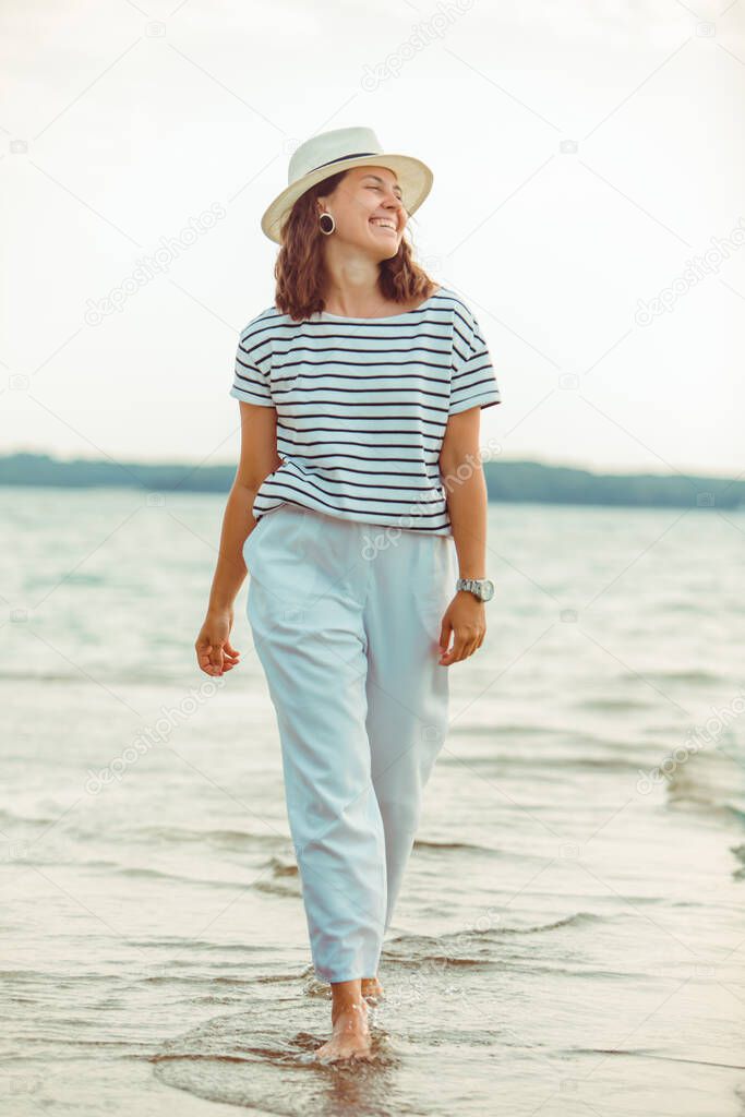 woman in white clothes walking by sea beach summer time