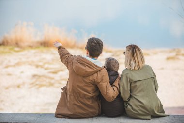 Sahilde gölü gören genç ve güzel bir aile. sonbahar sezonu
