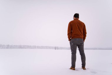 Adam kar mevsiminde açık havada duruyor.