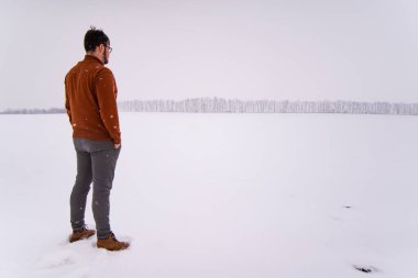 Adam kar mevsiminde açık havada duruyor.
