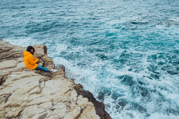 Mulher Sentada Borda Penhasco Olhando Ondas Grandes Mar — Fotografia de Stock