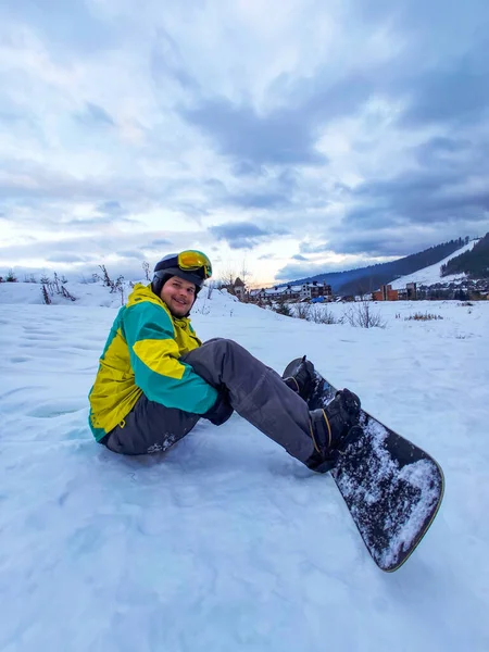 Man Met Snowboard Zittend Besneeuwde Heuvel Sport Activiteiten — Stockfoto