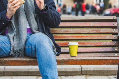 adam ellerini burger kahve fincanı ile dayanabiliyor kapatın. açık havada