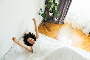 Genç ve güzel bir kadın beyaz çarşaflı parlak ışık fotokopi alanı
