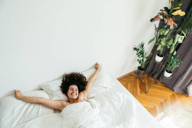 Genç ve güzel bir kadın beyaz çarşaflı parlak ışık fotokopi alanı