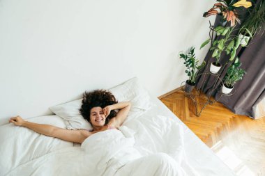 Genç ve güzel bir kadın beyaz çarşaflı parlak ışık fotokopi alanı