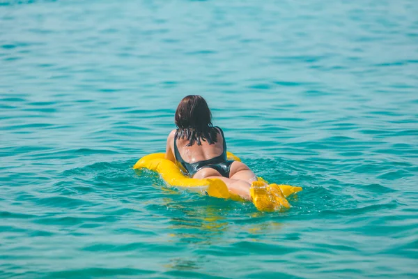 Sarı Şişme Yataklı Kadın Yaz Tatilinde Deniz Manzarasında Yüzüyor — Stok fotoğraf