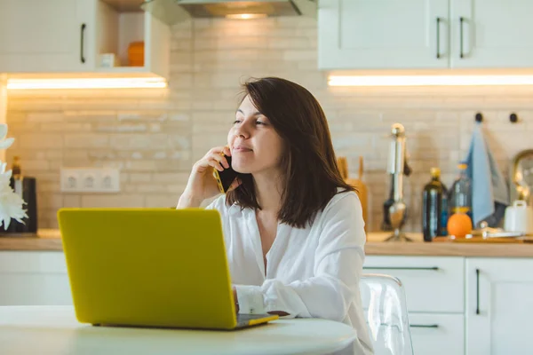 Young Pretty Caucasian Woman Talking Phone Sitting Front Laptop Kitchen — Stock Photo, Image