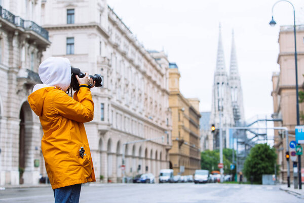 photographer tourist taking picture of city street with votive church on background vienna austria
