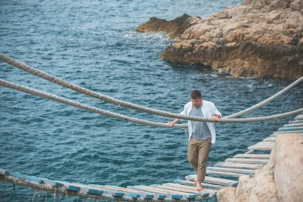 Homem Andando Por Ponte Suspensa Cruzar Mar Baía Penhasco Rochoso — Fotografia de Stock